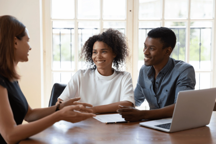real estate agent sitting at table and helping clients 